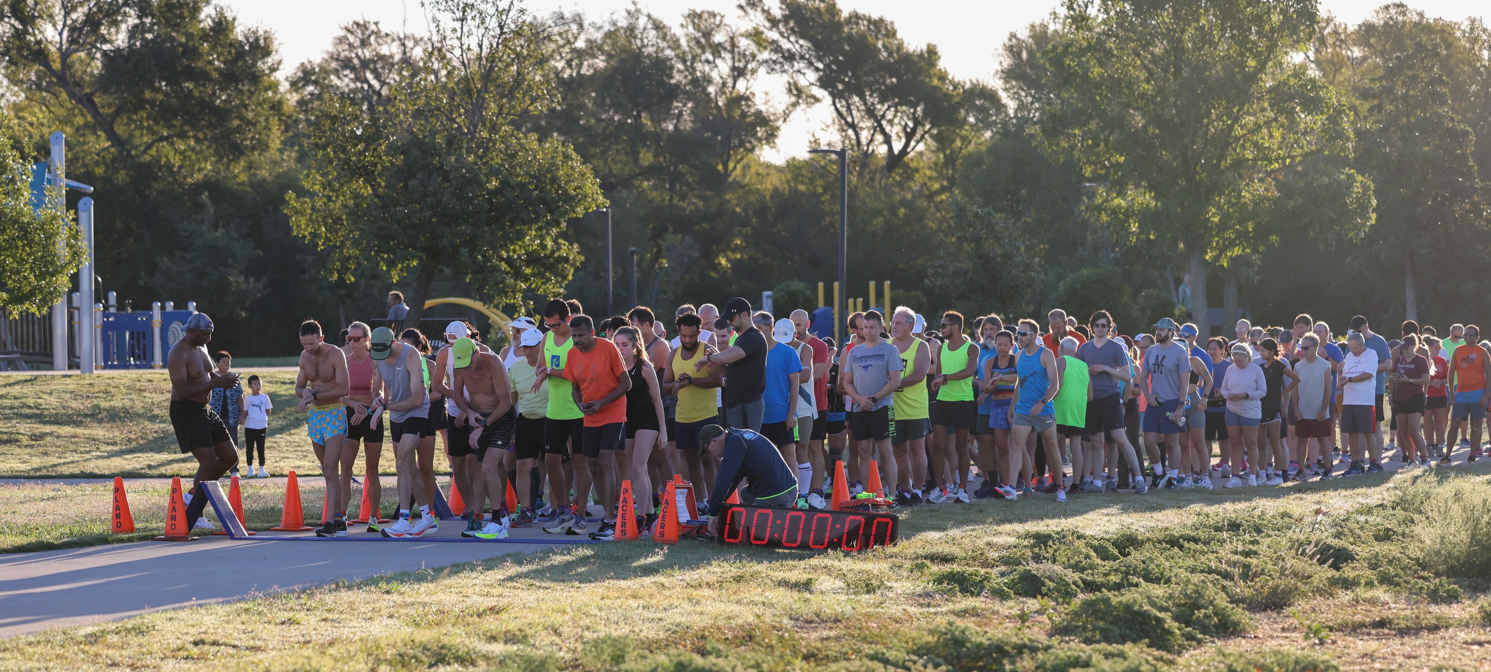 Runners lined up to start a race on a path in a park